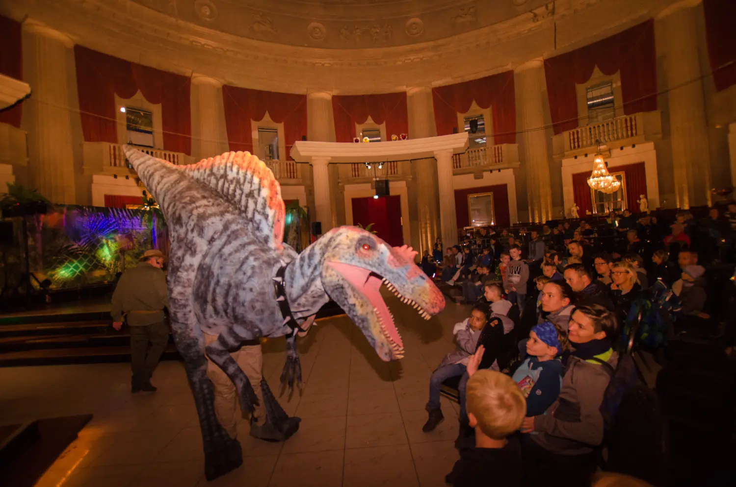 Die lebendige Dinosaurier Show, Kinder um einen Dinosaurier mit offenem Maul 